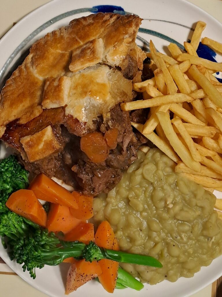 Beef and Guinness pie with buttered vegetables and mushy peas