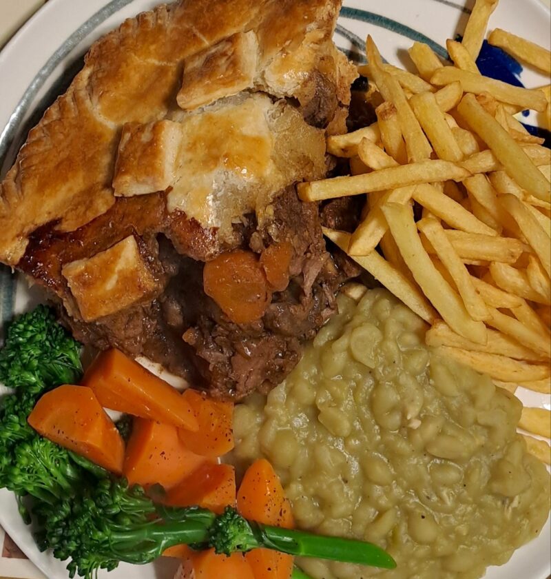 Beef and Guinness pie with buttered vegetables and mushy peas