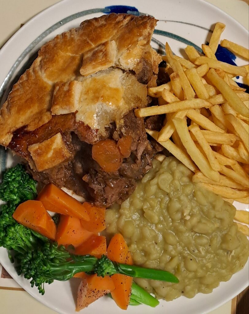 Beef and Guinness pie with buttered vegetables and mushy peas