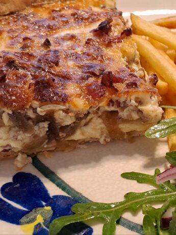 Cheesy quiche Lorraine with salad and chips