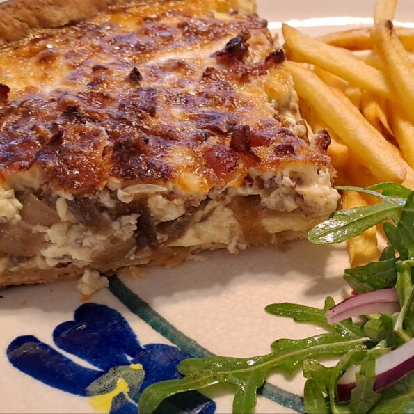 Cheesy quiche Lorraine with salad and chips